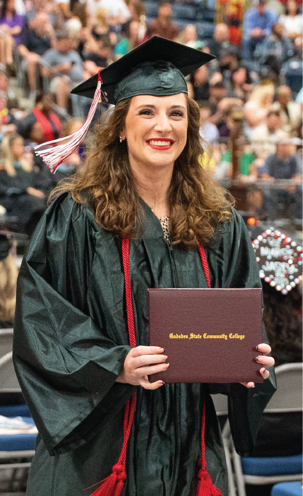 Student from Gadsden State in graduation cap and gown holding diploma