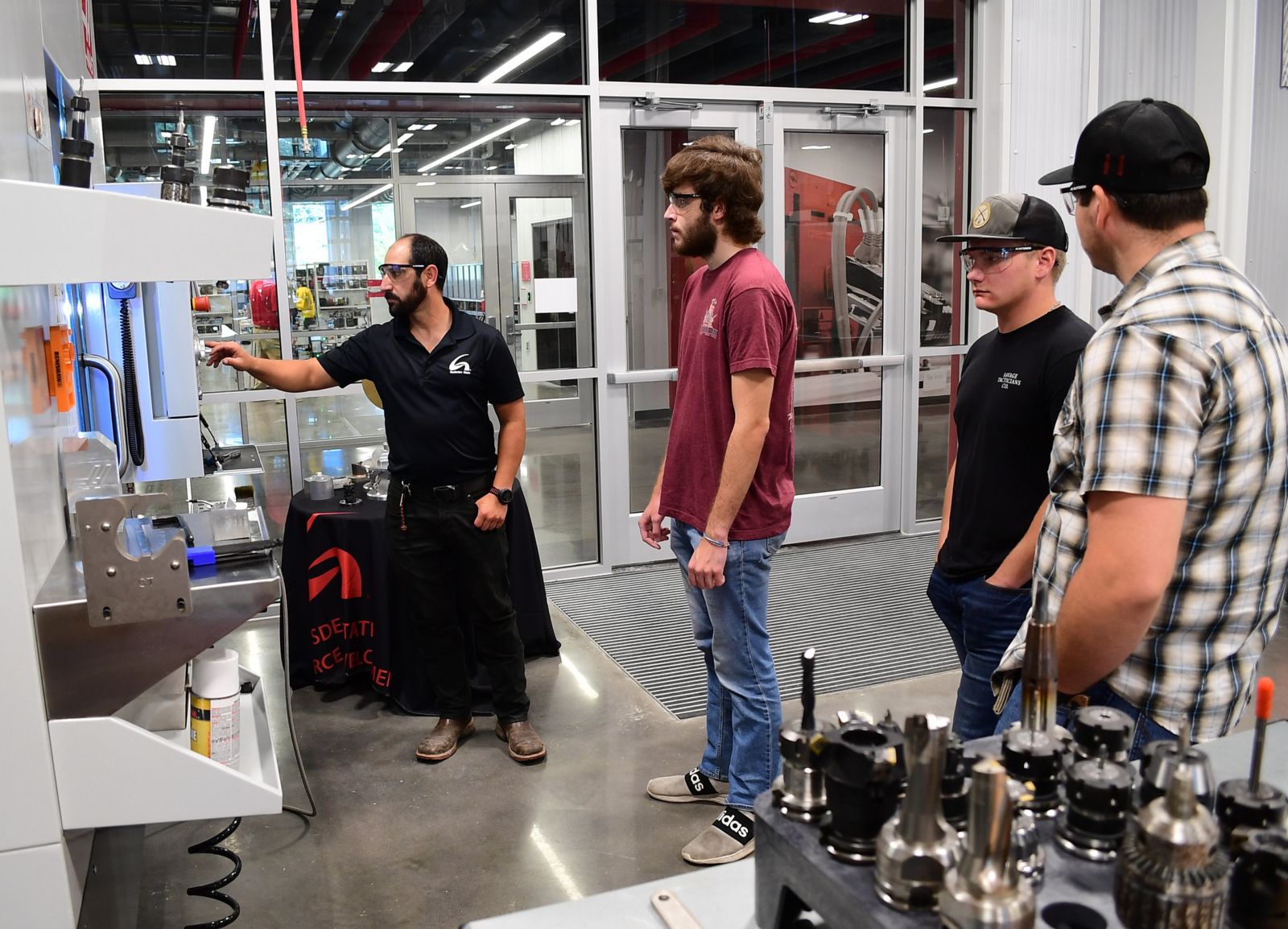 Precision Machining Instructor Daniel Anderson, far left, demonstrates on machining equipment in the Gene Haas Center for Advanced Machining and Engineering Technology. Students are, from left, Thomas Yohe, Harrison Goforth and Justin Bashe.