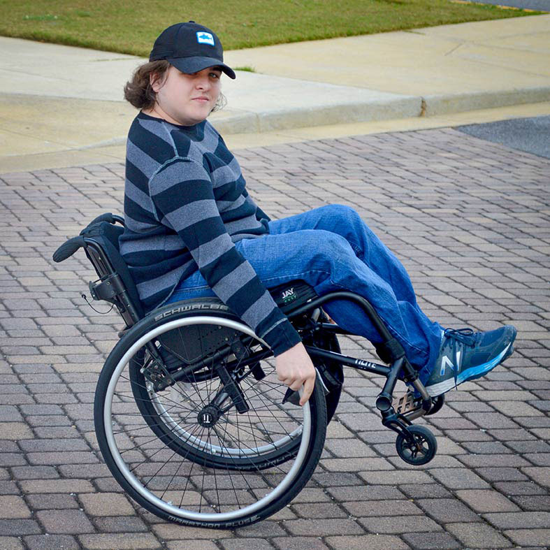 A student navigating campus in a wheelchair