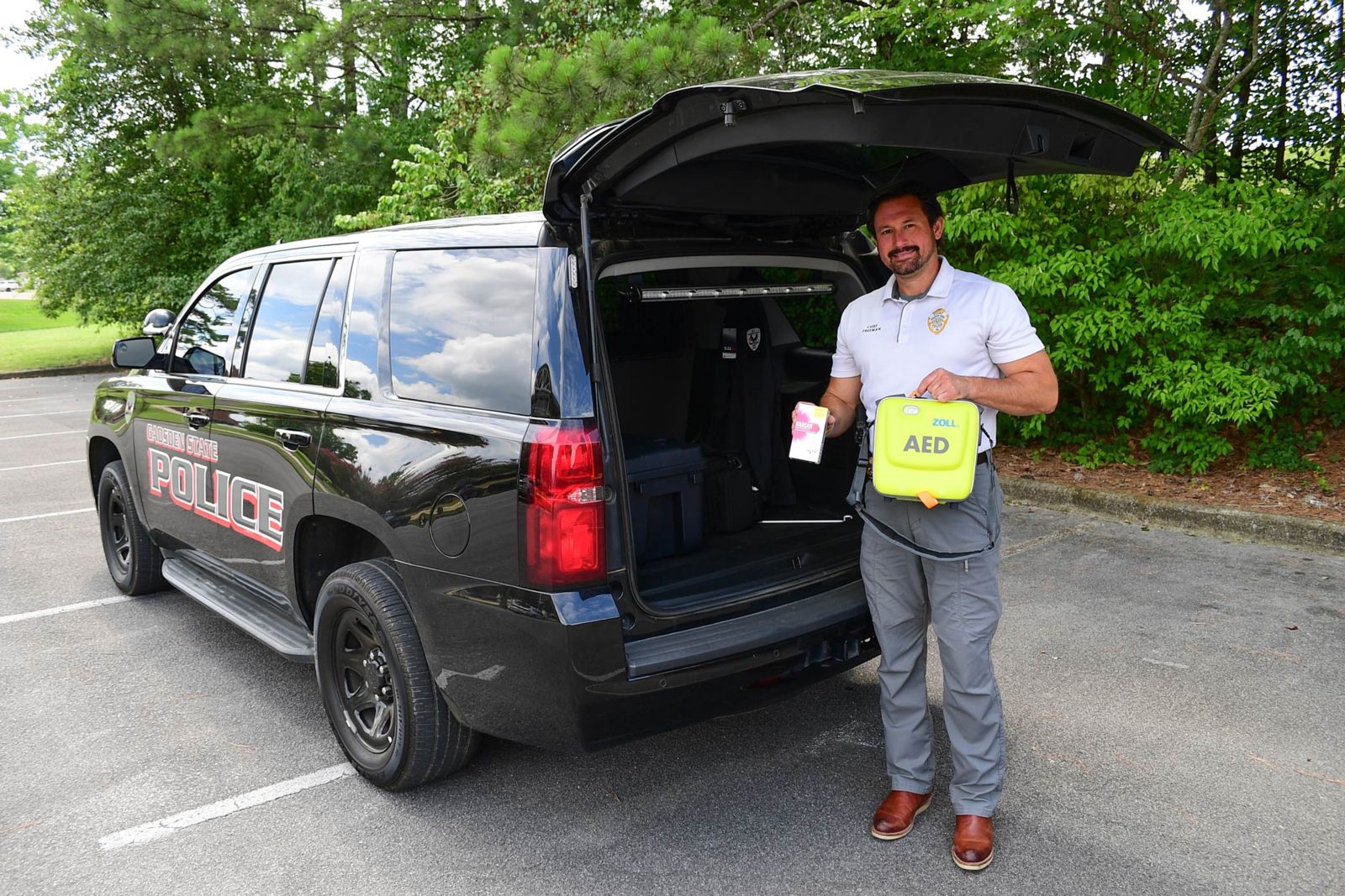 Chief Jay Freeman with one of the Police and Public Safety Department vehicles, which are now equipped with Automated External Defibrillators and Narcan, an opioid overdose reversal medication