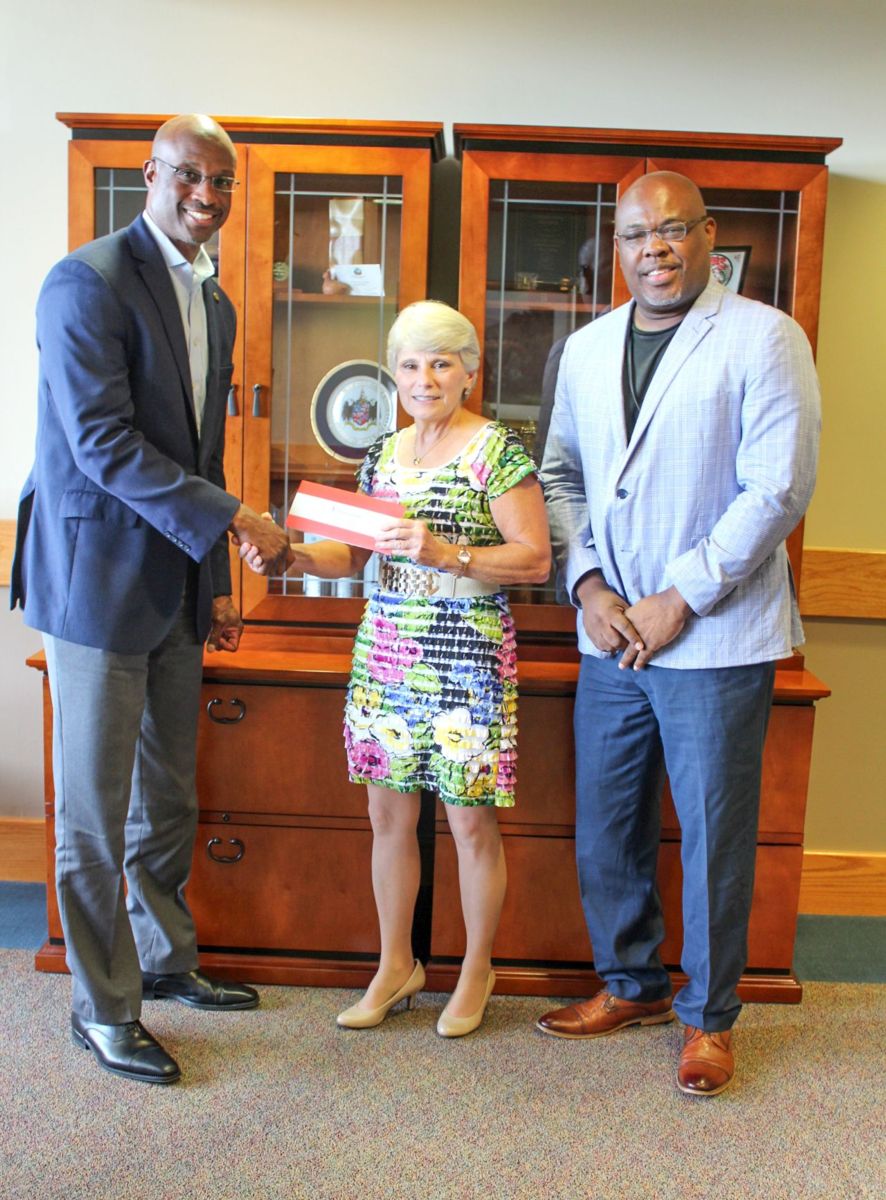 Alabama Power executives Terry Smiley, left, and Spencer Williams, right, present a $50,000 check to Dr. Kathy Murphy, president of Gadsden State