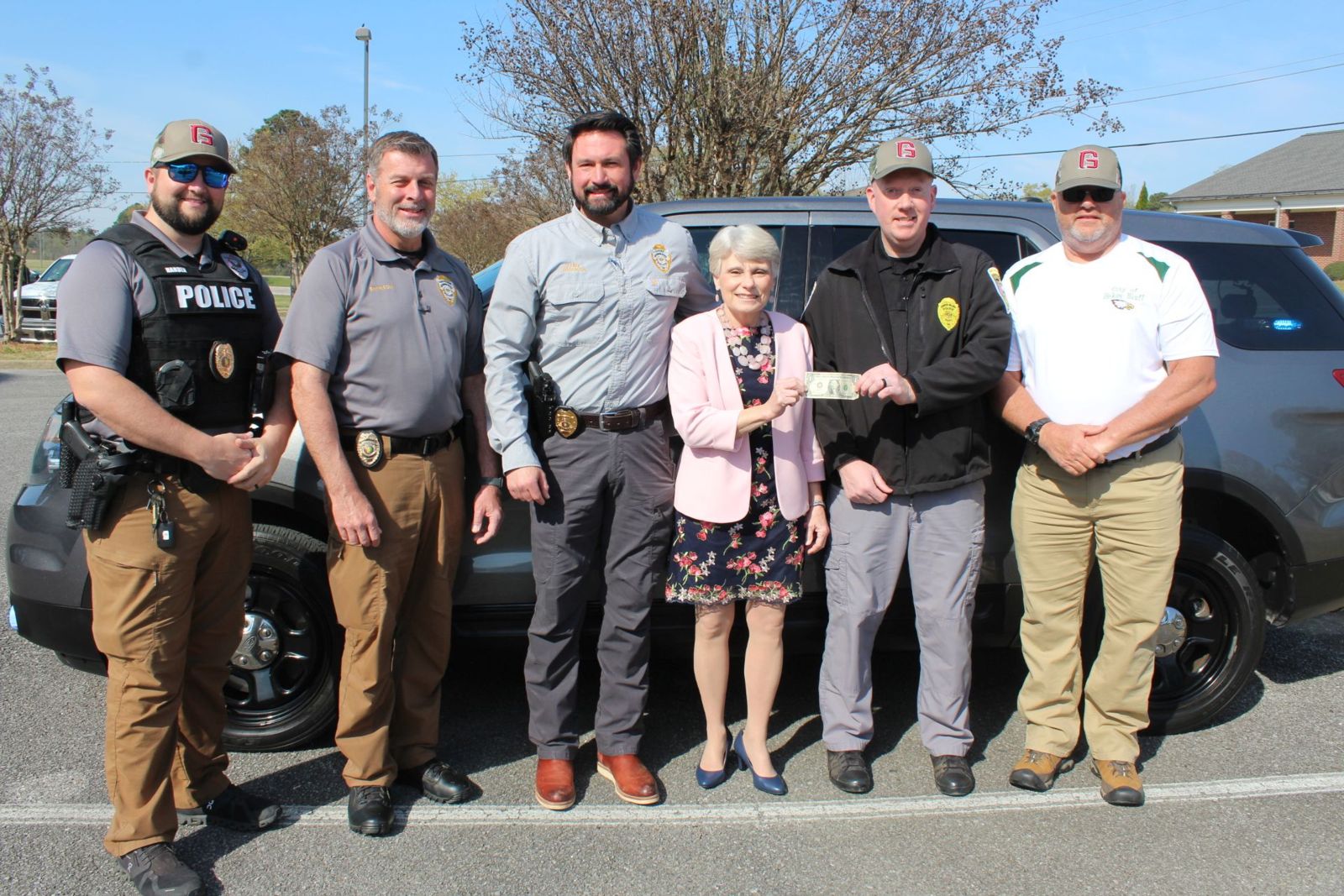 Dr. Kathy Murphy, president of Gadsden State, presents a dollar to Hokes Bluff Chief of Police Tyler Roe in exchange for a fully-equipped Ford Explorer. Joining them are, from left, Sgt. Colton Harden, Sgt. David Bankson and Chief Jay Freeman, all of the Gadsden State Police and Public Safety Department, and Hokes Bluff Mayor Scott Reeves.
