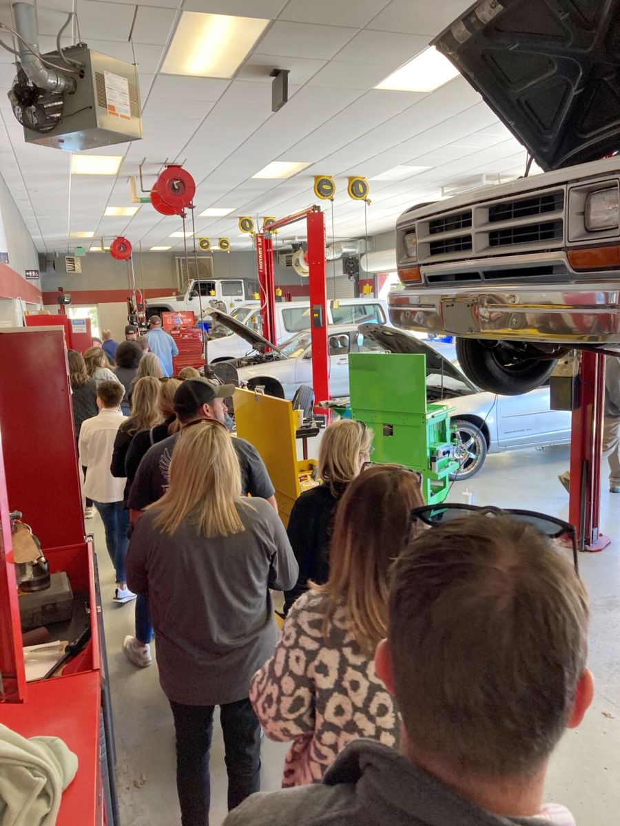 A group of educators participating in EQWIP walk through the hands-on learning space in the Automotive Services Technology Program.