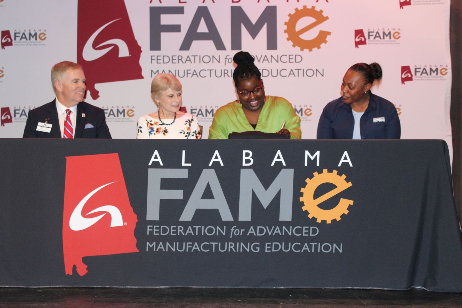Taleasha Smoot signs her FAME pledge and commitment to Bridgewater Interiors at the FAME Signing Day held May 18 at the Oxford Civic Center. She is pictured with, from left, Alan Smith, dean of Workforce Development; Dr. Kathy Murphy, president of Gadsden State; and April Stillwell, training and development coordinator at Bridgewater Interiors.