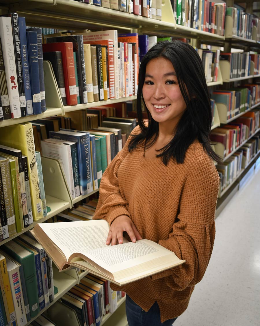A student in the library on the Wallace Drive Campus