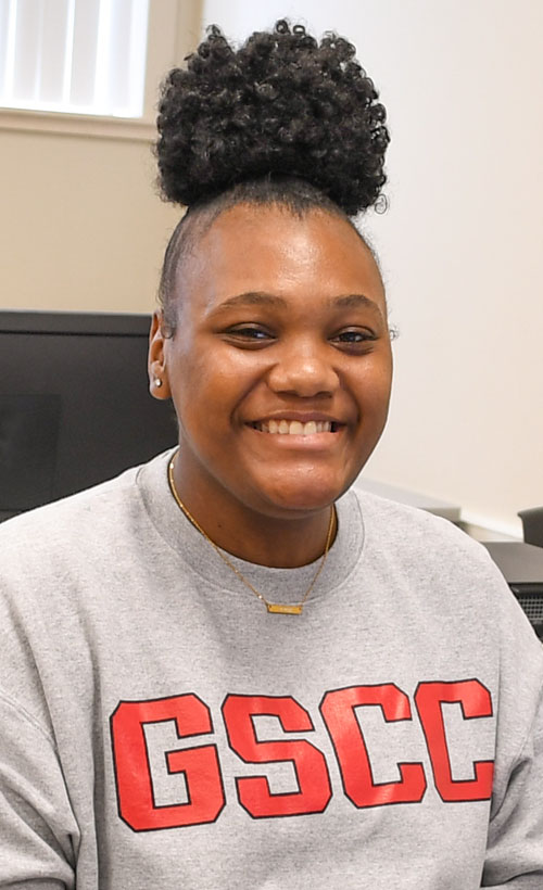 Student wearing GSCC sweater smiling